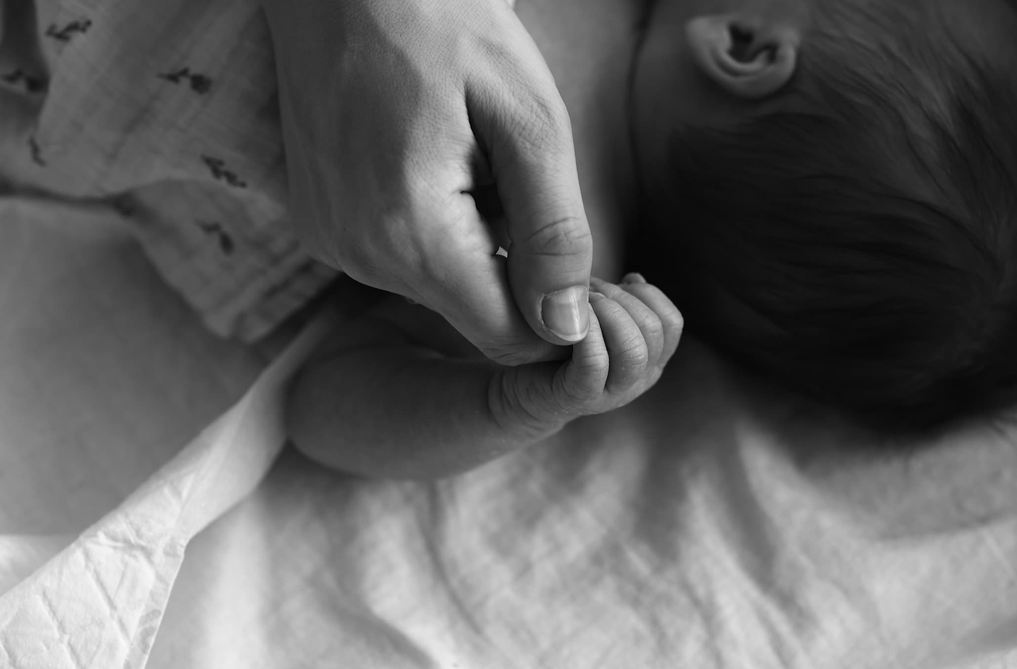 Dłoń mamy trzymająca dłoń niemowlęcia